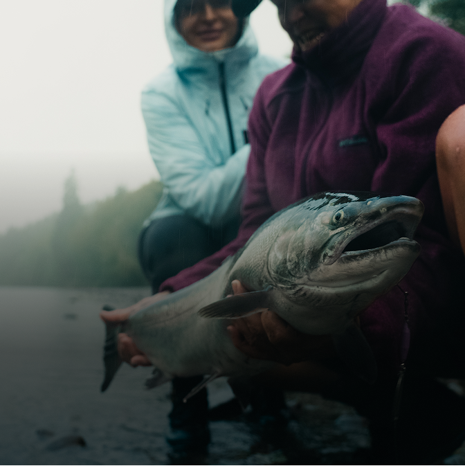 two people with a fish caught with an eagle rod