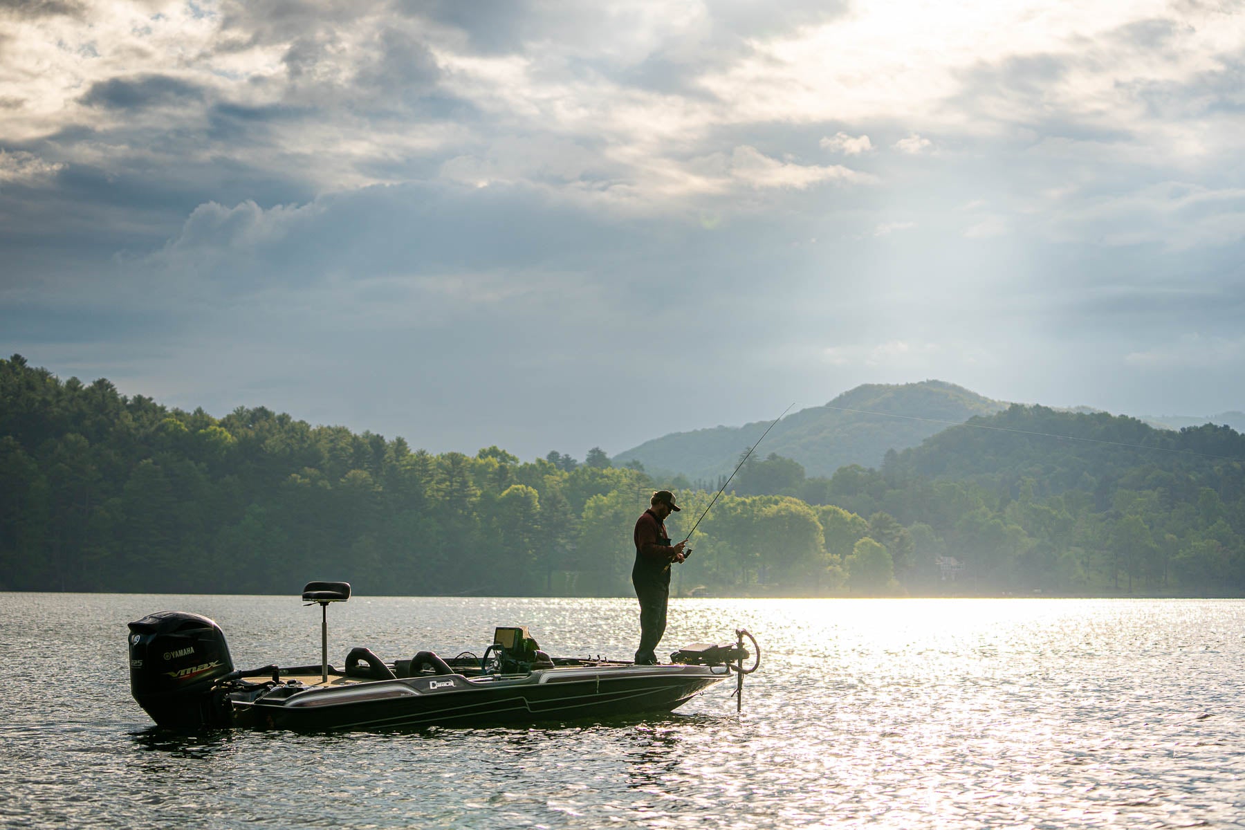 Man on a boat fishing on a lake